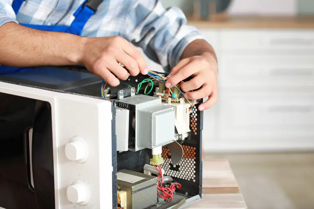 Technician performing gas oven repair and igniter replacement in San Antonio, TX