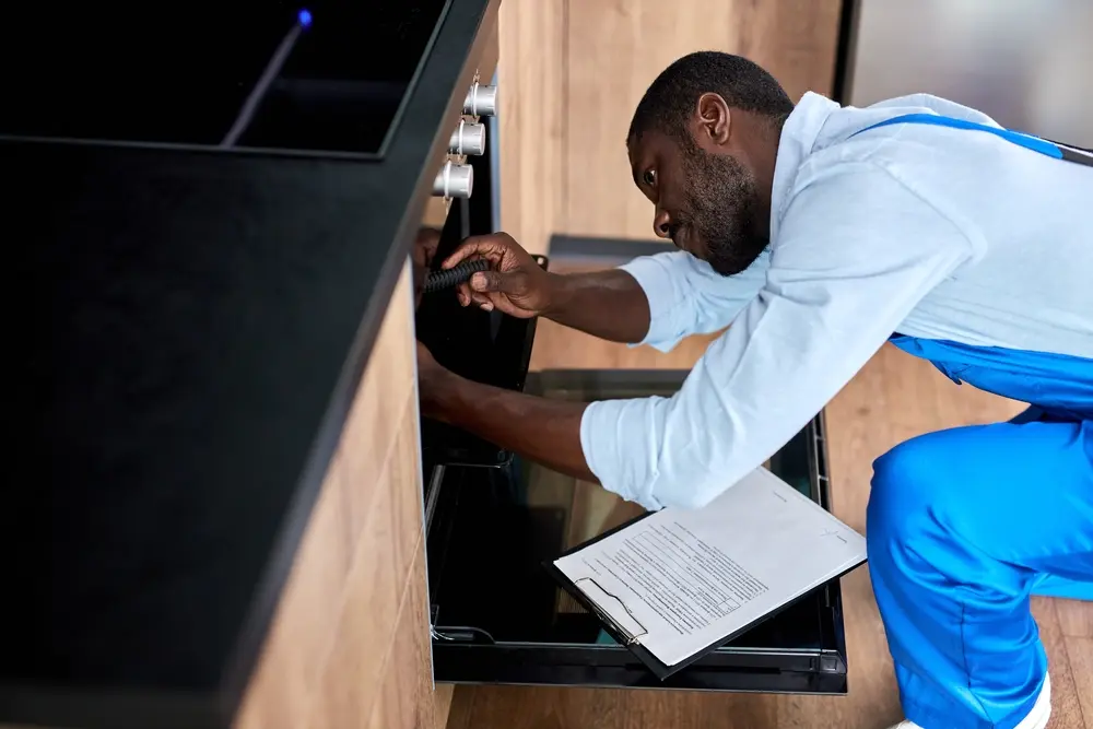 Oven repair technician explaining flat-rate appliance repair pricing to customer